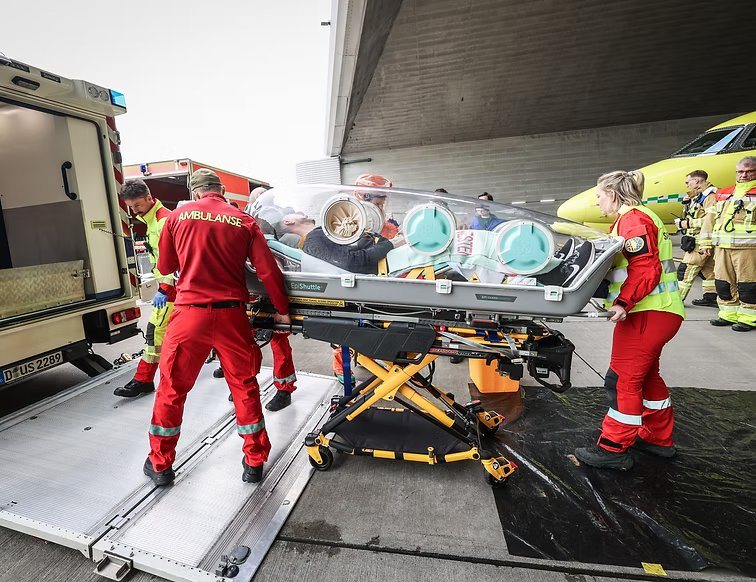 Crew moving a patient in an EpiShuttle from a ground ambulance