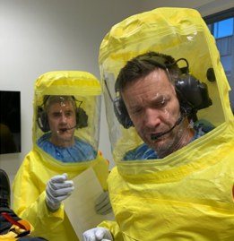 Two crew members in full protective suits