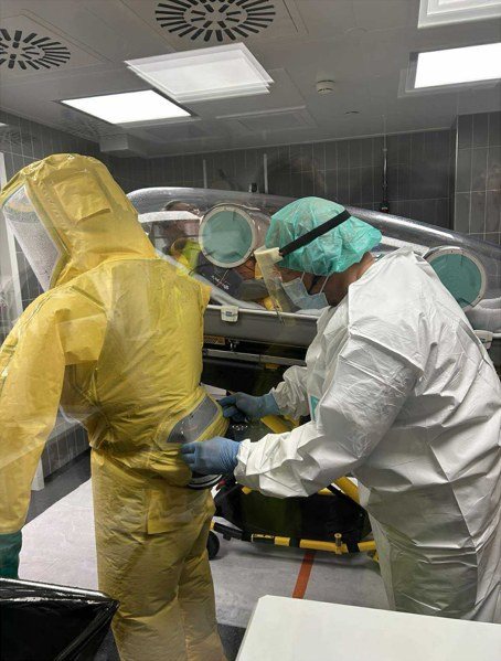 Staff in protective suits preparing a patient in an EpiShuttle